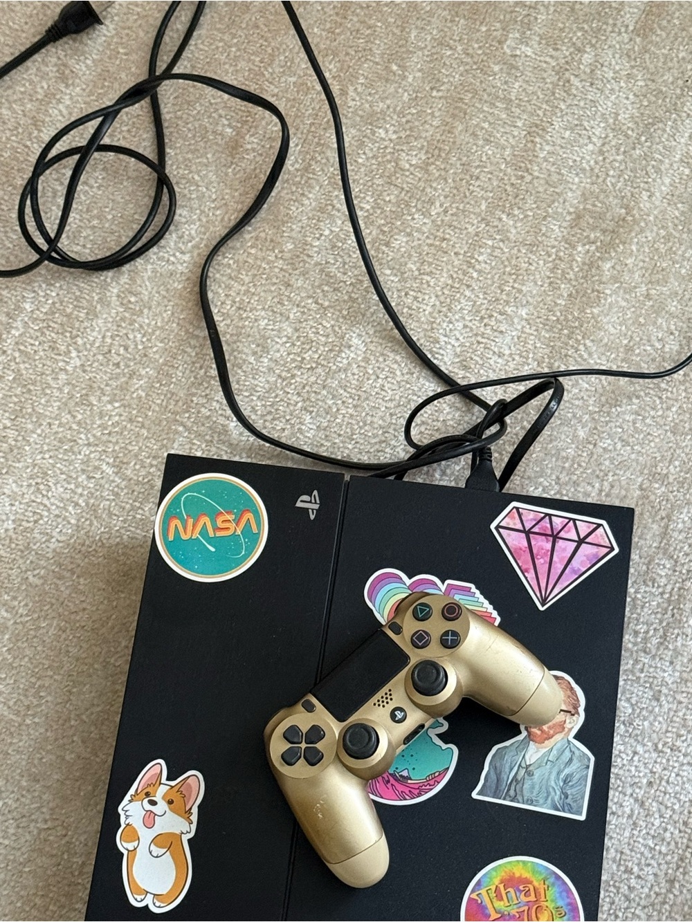 Black Gaming Console with Gold Wireless Controller and Decorative Stickers